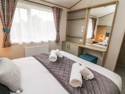 a bedroom with a bed with towels on it at Barney's Retreat in Carnforth