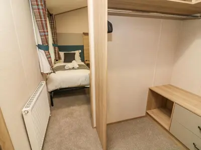 a small room with a bed and a small closet at Barney's Retreat in Carnforth