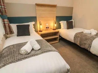 two beds in a hotel room with white towels at Barney's Retreat in Carnforth