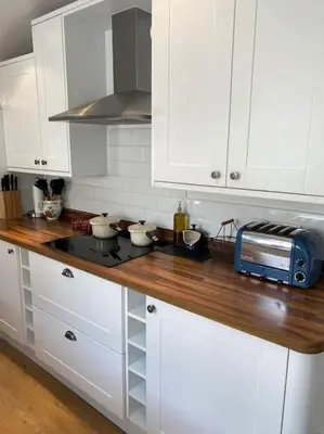 a kitchen with white cabinets and a counter with a microwave at Cheerful and spacious 3 bed home in Clitheroe in Clitheroe