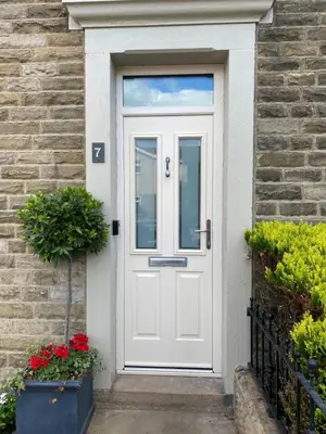 a white door on a brick house with flowers at Cheerful and spacious 3 bed home in Clitheroe in Clitheroe