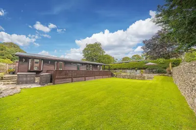 a house with a large lawn in front of it at North Lodge Cartmel in Cartmel