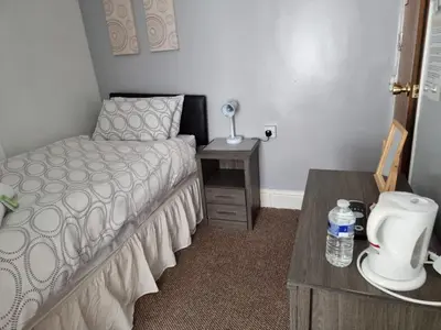 a bedroom with a bed and a table with a bottle of water at Casablanca in Blackpool