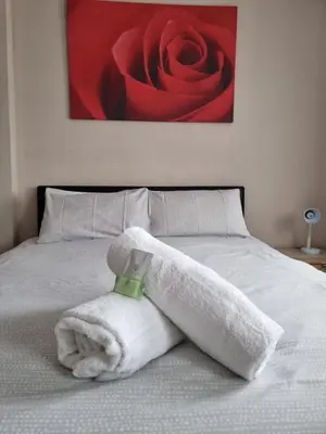 a white towel on a bed with a red rose at Casablanca in Blackpool
