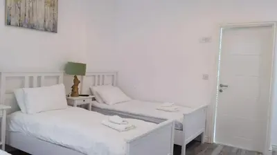 a white room with two beds and a mirror at CityBreaks Rooms with Free Parking in Liverpool