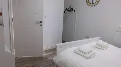 a white bedroom with two towels on a bed at CityBreaks Rooms with Free Parking in Liverpool