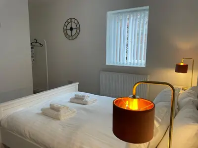 a bedroom with a bed with towels and a lamp at CityBreaks Rooms with Free Parking in Liverpool