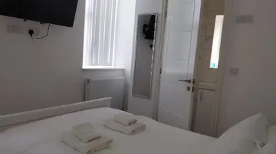 a white bedroom with two towels on a bed at CityBreaks Rooms with Free Parking in Liverpool