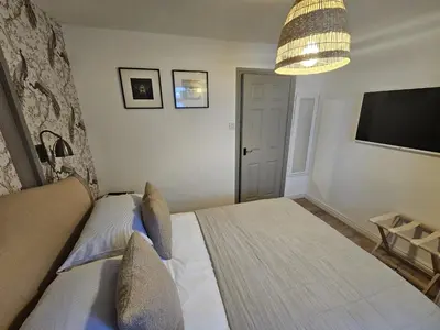 a bedroom with a large bed and a television at Shakespeare’s Nest in Prescot