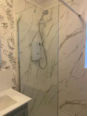 a shower with a glass door in a bathroom at Shakespeare’s Nest in Prescot