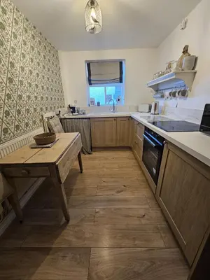 a kitchen with a wooden table and a sink at Shakespeare’s Nest in Prescot