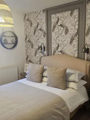 a bedroom with a large white bed with a wall at Shakespeare’s Nest in Prescot