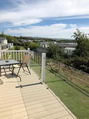 a wooden deck with a table and chairs on it at Tranquility No 42 Port Haverigg Marina in Millom