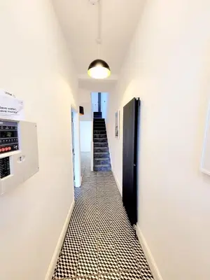 a hallway with white walls and a black door at Beautiful Georgian Mansion! by City Sparrow in Liverpool