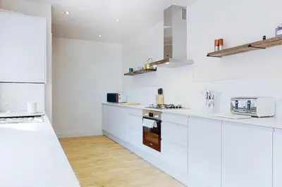 a white kitchen with white counters and white appliances at Lancefield House - Air Host & Stay - 5 Bedroom Sleeps 15 in Walton on the Hill