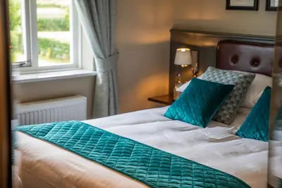 a bedroom with a bed with blue pillows and a window at Haighton Manor - Brunning and Price in Grimsargh
