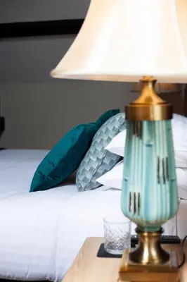 a green lamp on a table next to a bed at Haighton Manor - Brunning and Price in Grimsargh