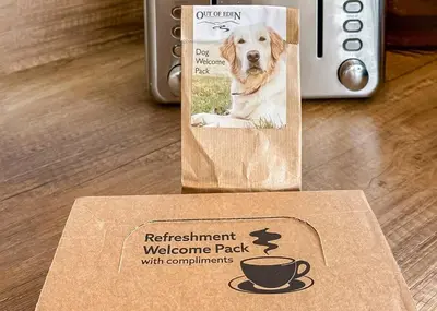 a dog in a bag with a cup of coffee at Waterside Hambleton Lakeside Lodges in Poulton le Fylde