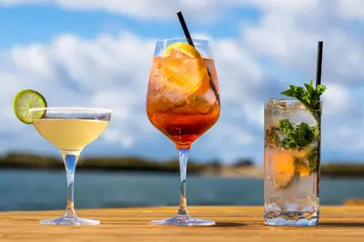 three cocktails sitting on a wooden table at The Lake House in Liverpool