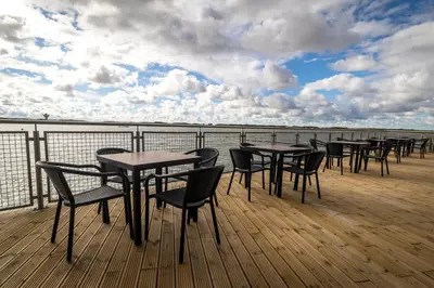 a row of tables and chairs on a deck at The Lake House in Liverpool