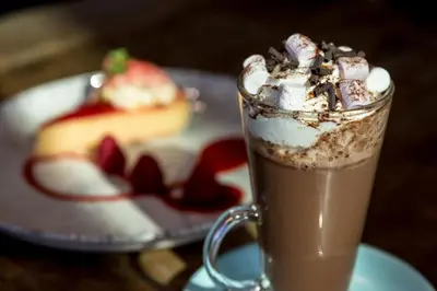 a glass of chocolate milkshake next to a plate of cake at The Lake House in Liverpool
