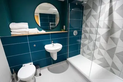 a bathroom with a toilet and a sink and a mirror at The Lake House in Liverpool