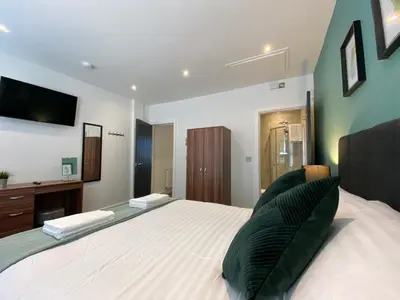 a bedroom with a large bed with a television on the wall at Modern 3 bedroom apartment close to the city centre in Liverpool