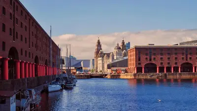 a river in a city with buildings and boats at Modern 3 bedroom apartment close to the city centre in Liverpool