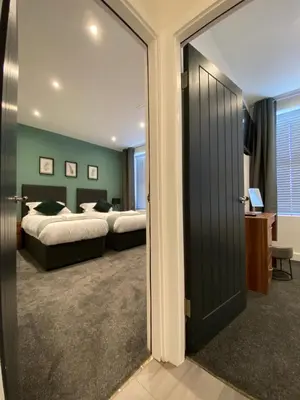 a bedroom with two beds and a sliding glass door at Modern 3 bedroom apartment close to the city centre in Liverpool