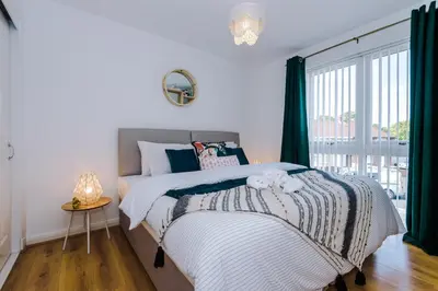 a bedroom with a bed and a large window at Liverpool 4 Bed! Sleeps 9! Groups and Contractors! FREE OFF STREET PARKING! 3 Toilets! FREE WIFI! in West Derby