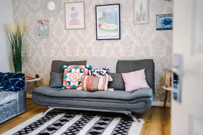 a living room with a couch with pillows on it at Liverpool 4 Bed! Sleeps 9! Groups and Contractors! FREE OFF STREET PARKING! 3 Toilets! FREE WIFI! in West Derby