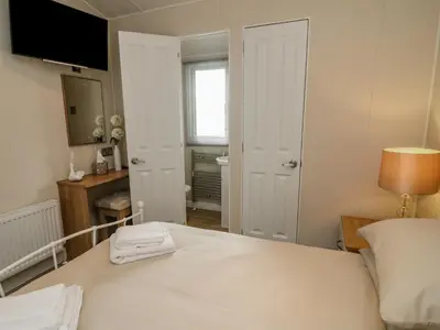 a bedroom with a white bed and a television at Number 15 in Carnforth