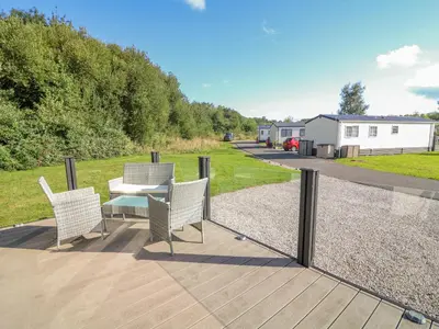 a patio with a table and chairs on a deck at Number 15 in Carnforth