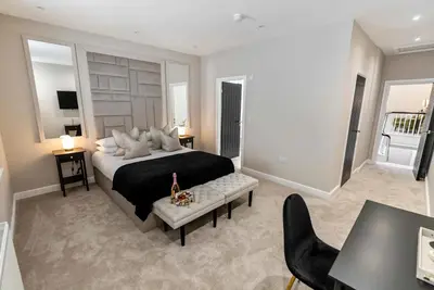 a bedroom with a large bed and a table and chairs at The Burlington by STAMP SA in Blackpool