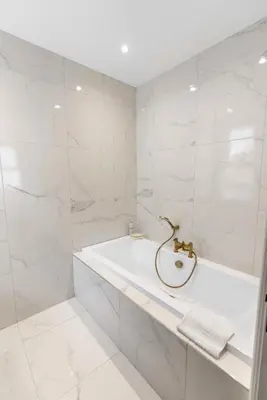 a white bathroom with a tub and a sink at The Burlington by STAMP SA in Blackpool