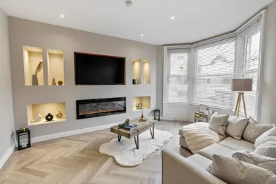 a living room with a couch and a tv at The Burlington by STAMP SA in Blackpool