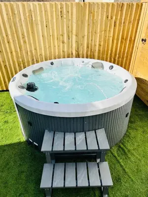 a hot tub in a backyard with a wooden fence at The Burlington by STAMP SA in Blackpool