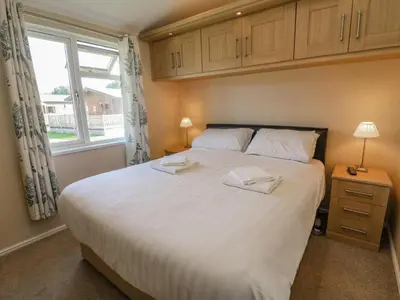 a bedroom with a large white bed with a window at Gressingham 22 in Carnforth