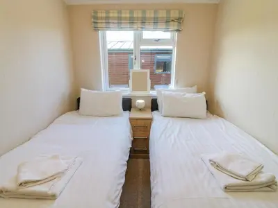 two beds in a small room with a window at Gressingham 22 in Carnforth