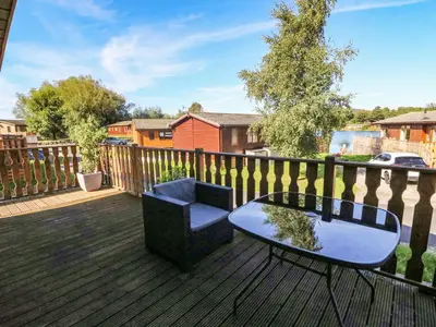 a patio with a table and a chair on a deck at Gressingham 22 in Carnforth