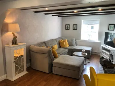 a living room with a couch and a table at Old Smithy Cottage in Great Singleton