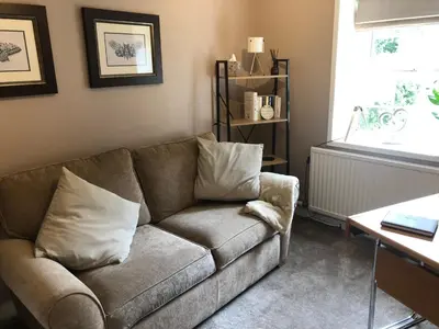 a living room with a couch and a window at Old Smithy Cottage in Great Singleton