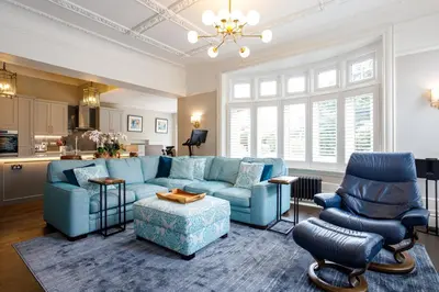 a living room with a blue couch and chairs at Tranquil Apartment in Merseyside in Liverpool