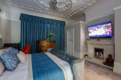 a bedroom with a bed and a tv and a fireplace at Tranquil Apartment in Merseyside in Liverpool