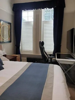 a bedroom with a bed and a desk and a television at Tranquil Apartment in Merseyside in Liverpool