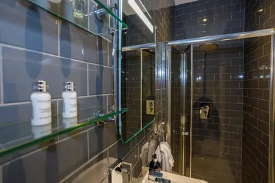 a bathroom with a shower with a mirror and a sink at Tranquil Apartment in Merseyside in Liverpool
