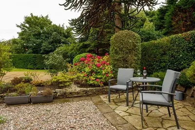 a garden with a table and chairs and flowers at Tranquil Apartment in Merseyside in Liverpool