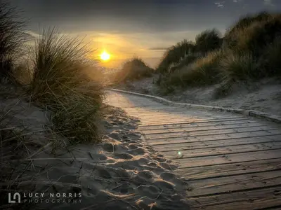 a wooden path on the beach at sunset at Tranquil Apartment in Merseyside in Liverpool