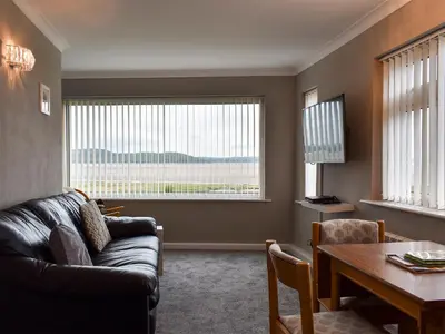 a living room with a couch and a table at Dolphin Cottage in Grange Over Sands