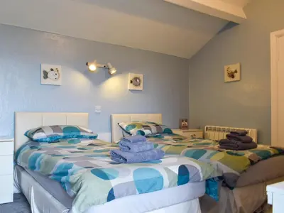 two beds sitting next to each other in a bedroom at Dolphin Cottage in Grange Over Sands